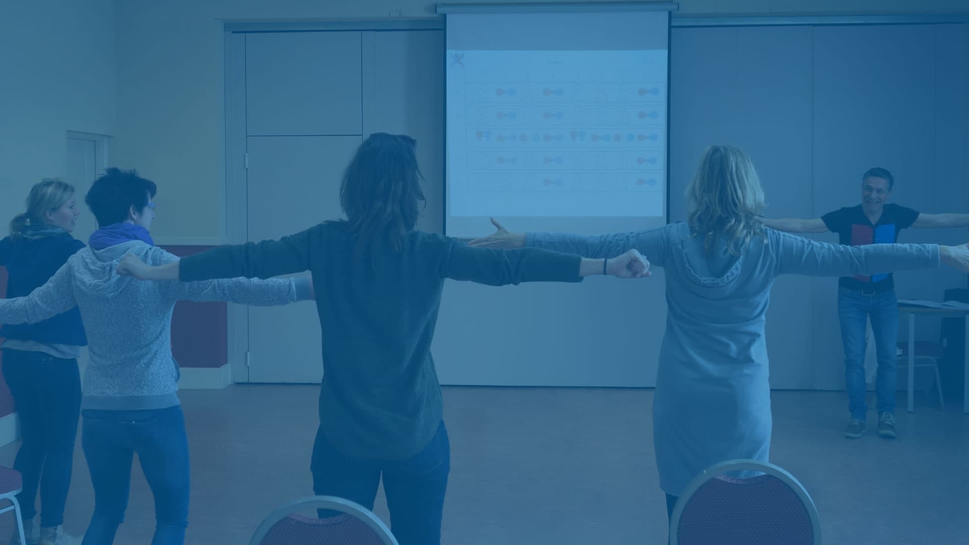 Trainer in front of a group of participants, seen from behind